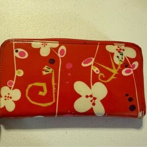 Pylones large "Voyage" wallet with a white flower/orchid pattern red Background